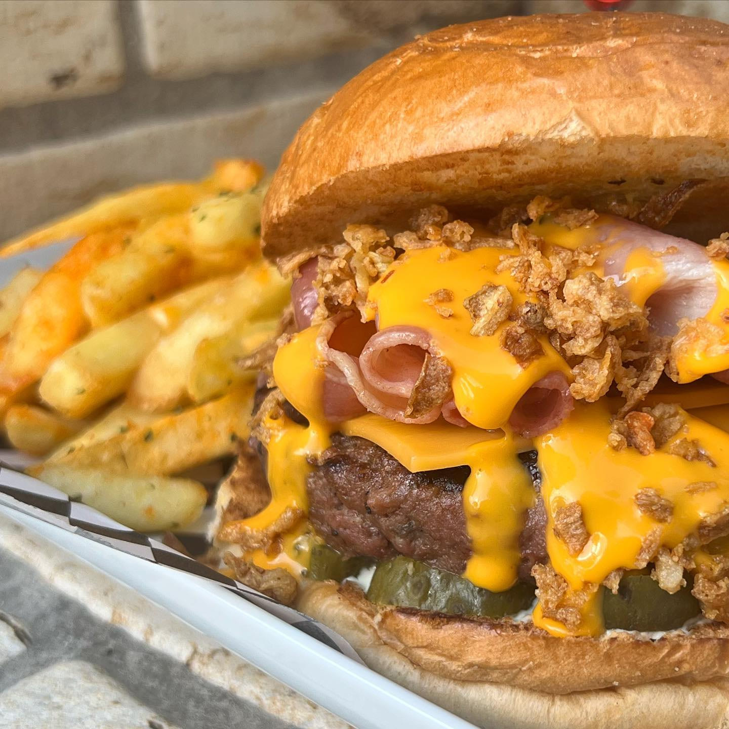 Juicy bacon cheeseburger con cebolla crujiente y patatas especiadas de Dogo's Grill Madrid