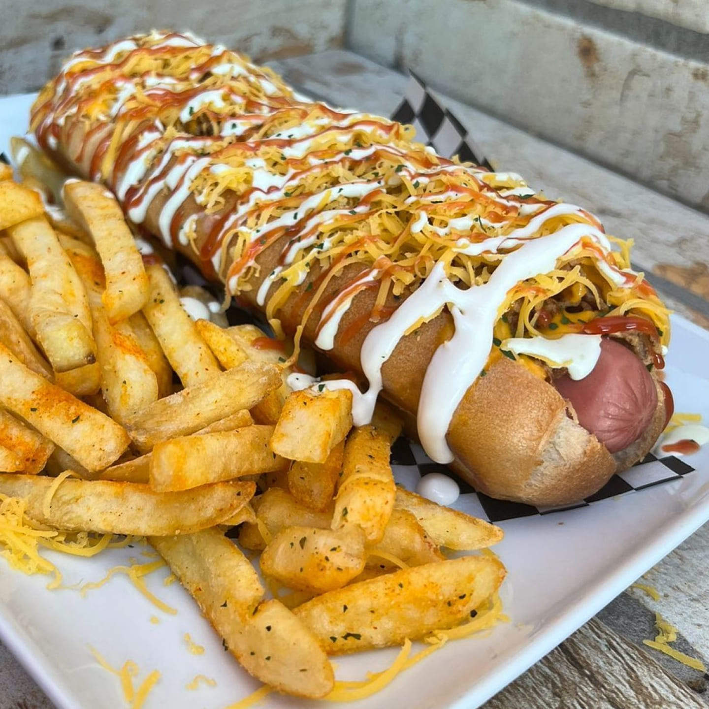 Hot dog gigante con una variedad de salsas y queso gratinado de Dogo's Grill, Madrid